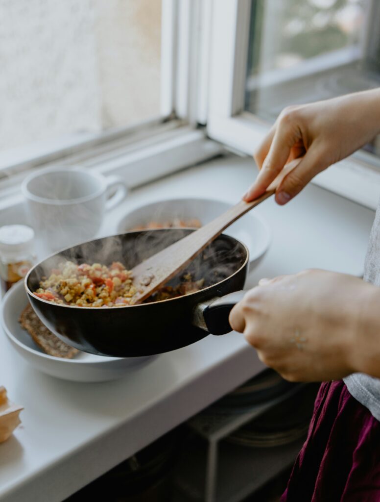 A picture of hands serving an easy one-pan meal into a bowl.